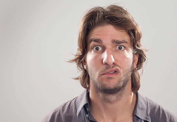Close up of a man with puzzled look on his face young man puzzled ugly face stock pictures, royalty-free photos & images