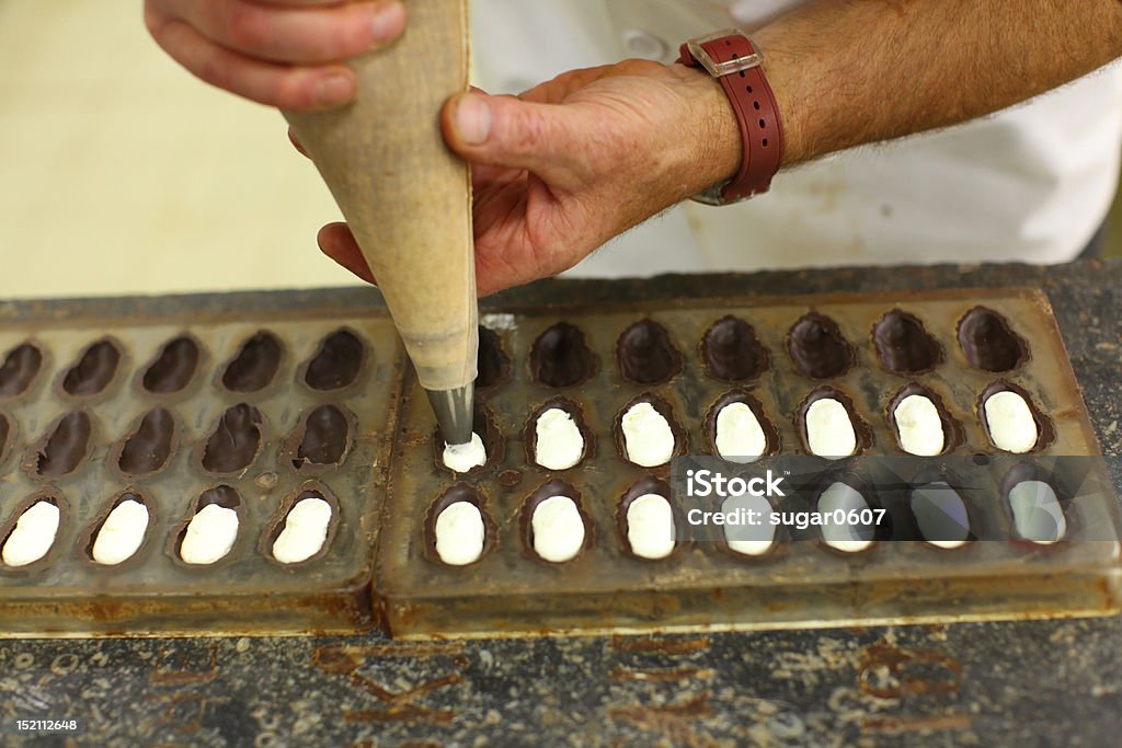 Maestri cioccolatieri creazione di praline con riempimento - Foto stock royalty-free di Belgio