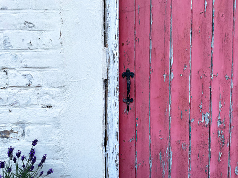 Old fashioned pink door with peeling paint