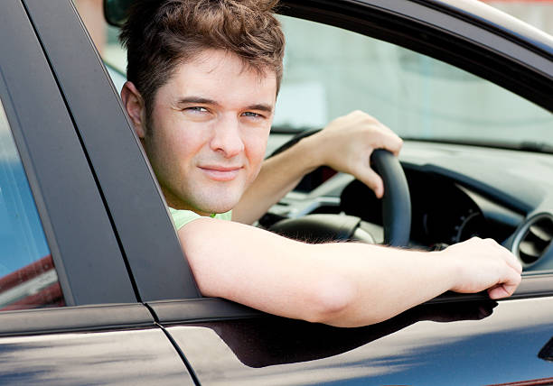 istock Happy young male driver sitting in his car looking outside 152113612
