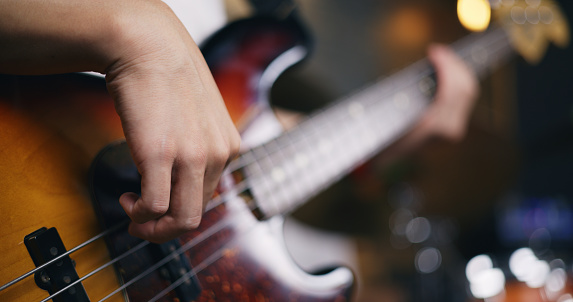 Portrait close-up of Young Asian male musicians in casual clothes playing electric guitars while rehearsing in an illuminated studio. Band practice in the studio. Music and entertainment concepts.