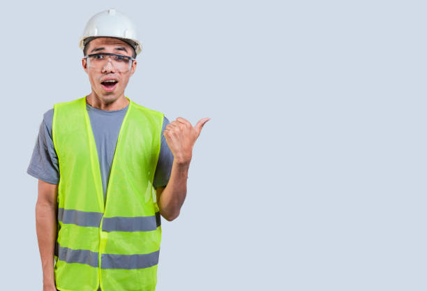 istock Young man in construction vest pointing at advertisement isolated.Handsome engineer wearing safety helmet and reflective jacket pointing to the side isolated 1521152014