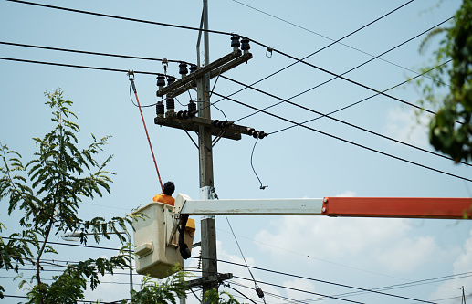 electrician using clamp stick (insulated tool) to restore power on the electric pole