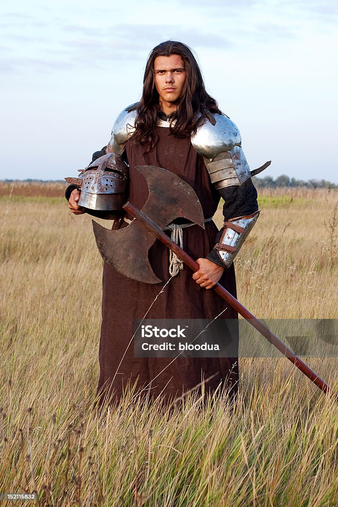 Medieval knight Medieval knight in the field with an axe Agricultural Field Stock Photo