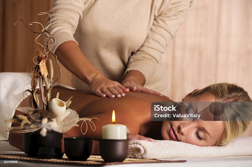 masseur doing  massaging  back of a beautiful young woman professional masseur doing  massaging  back of a beautiful young woman 20-29 Years Stock Photo