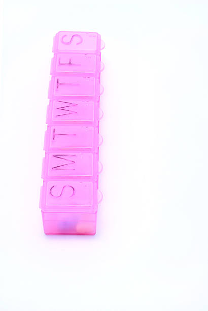 pink pill box on white stock photo