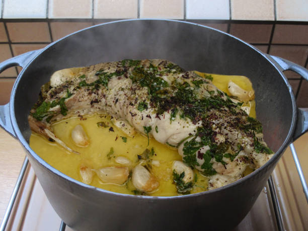 Monkfish being cooked with garlic, olive oil and lemon and seasoned with dried seaweed and parsley  French gourmet cuisine Monkfish being cooked with garlic, olive oil and lemon and seasoned with dried seaweed and parsley  French gourmet cuisine stargazer fish stock pictures, royalty-free photos & images