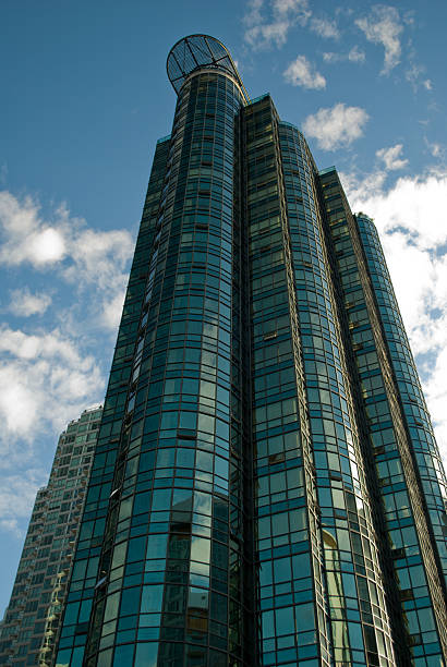 Modern High-Rise A modern high-rise on the background of blue light soaking up the sun. new urbanism stock pictures, royalty-free photos & images