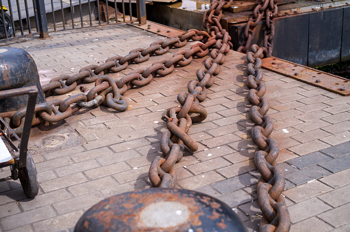 heavy rusty iron chains are placed around a bollard