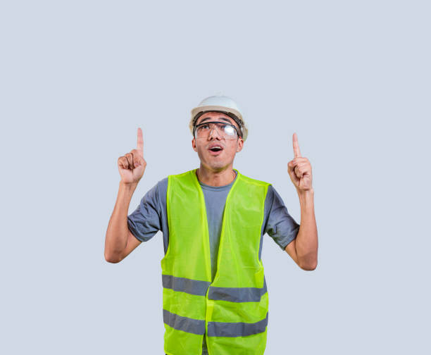 istock Builder engineer in a vest pointing at an advertisement. Engineer with amazed face pointing to a space 1521173631