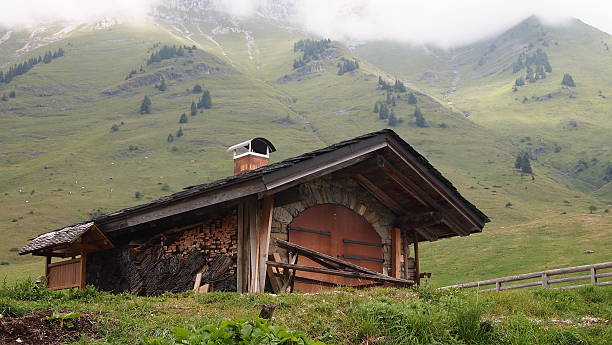 French chalet with surrounding moutains and light fog on the stock photo