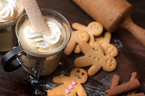 Gingerbread men cookie biscuits with hot coffee and whipped cream