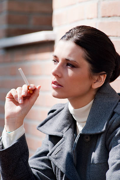 istock Young woman smoking outside 152120068