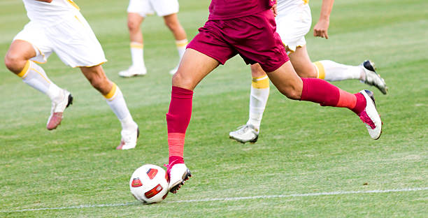 Soccer players running after the ball stock photo