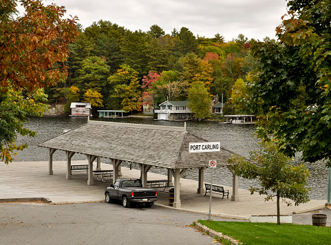 Port Carling city dock with colorful cottages and boathouses in background