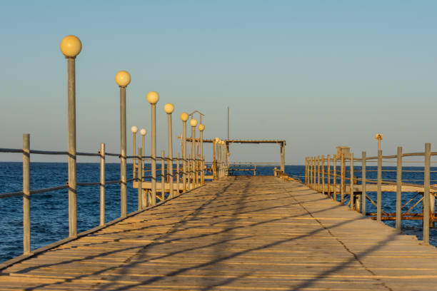 istock jetty with shadows in sun during the sunset at the beach 1521221478