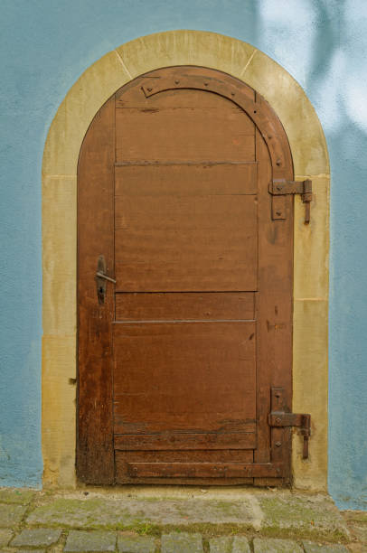 istock old brown wooden door in a blue wall 1521224566