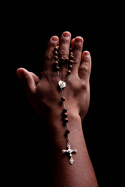 istock hands of a young latin men with crucifix 152123221