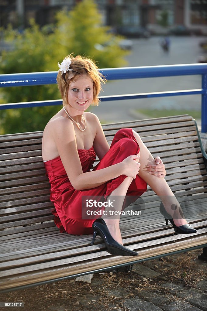 Lächelnd Teenager-Mädchen im roten Kleid sitzt auf Holzbank - Lizenzfrei Chattanooga Stock-Foto