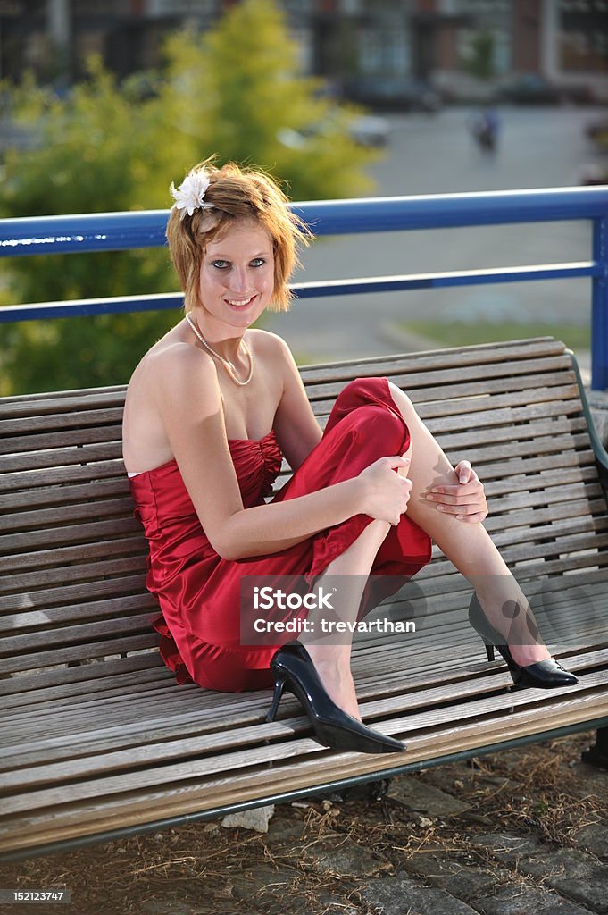 Teen sorridente Menina em Vestido de vermelho sentado num banco de Madeira - Royalty-free Chatanooga Foto de stock