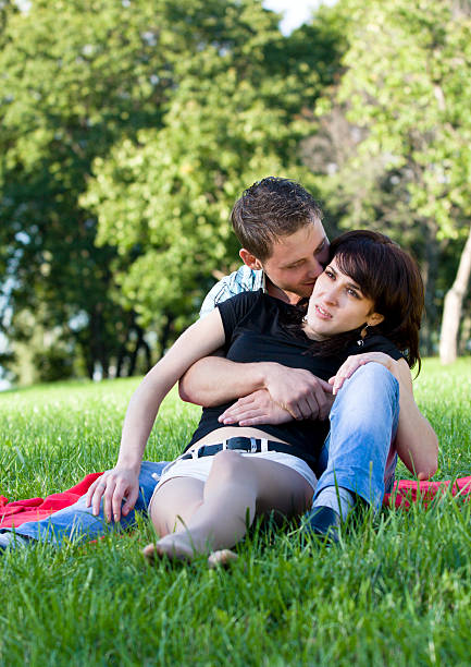 istock young couple sitting in the park embracing each ohter 152123838