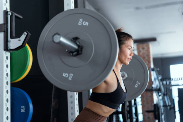 istock Fitness model performing weight lifting exercise at gym 1521245569