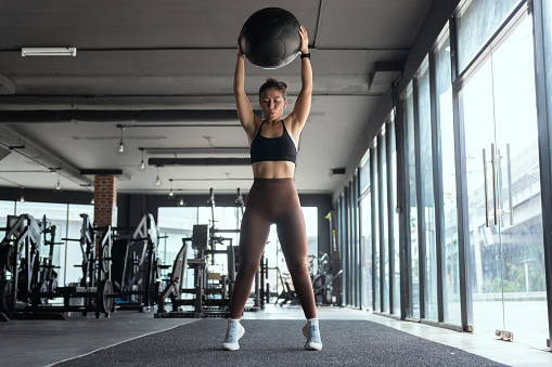 Asian woman exercising by lifting a ball in the gym. health fitness.