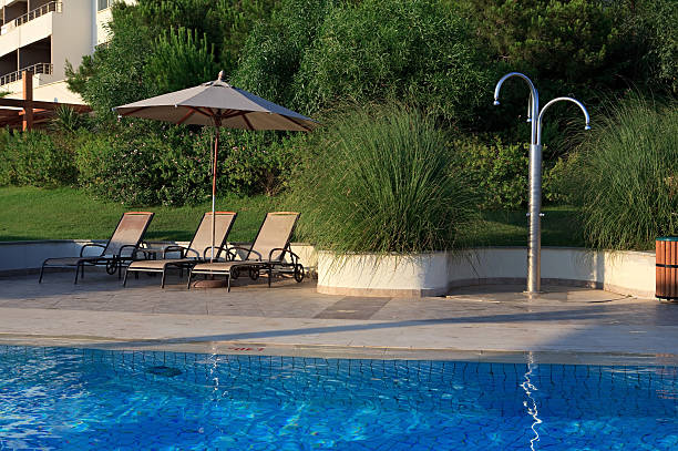 istock Sunbeds, umbrellas and shower near the pool. 152127886