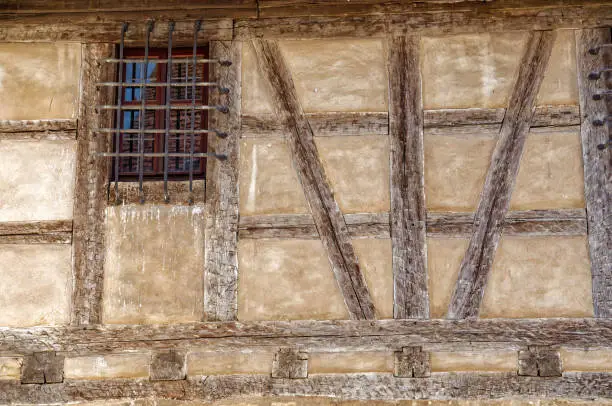 An old half-timbered with barred wooden window