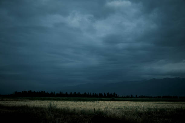 View of mountain ridge on horizon under cloudy sky at dawn