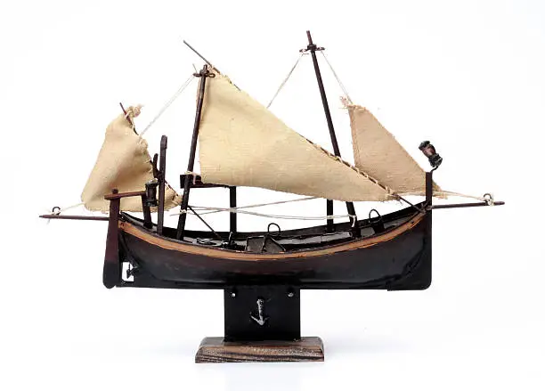 Model of ship with sails on a white background
