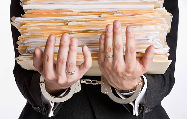 istock Businessman in Handcuffs Holding File Folders 152130100