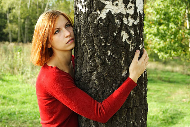 istock beauty girl hug a tree, half body, looking at side 152130163