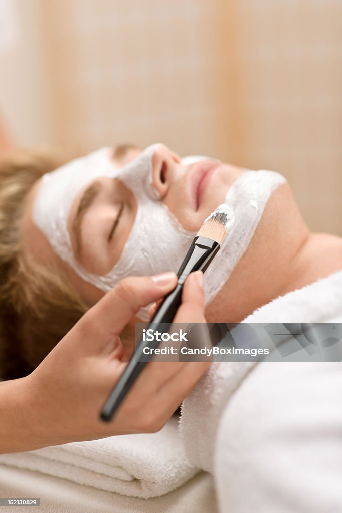 Male cosmetics - man having facial mask Male cosmetics - man having facial mask in luxury spa center Adult Stock Photo