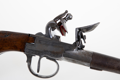 old gun historical detail trigger flint on white background