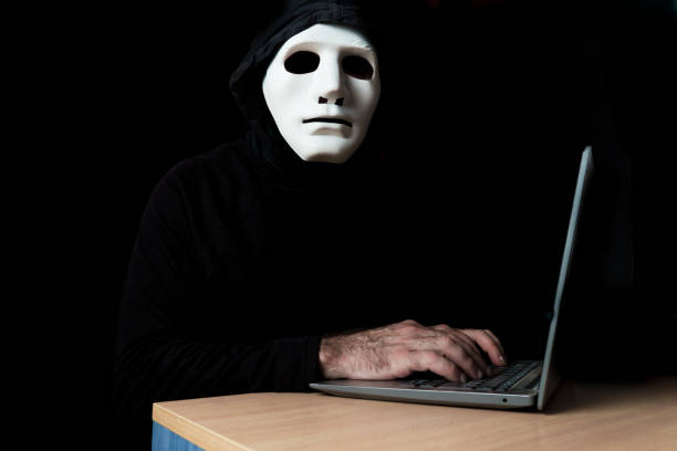 istock hacker dressed in black with mask and hood 1521314814