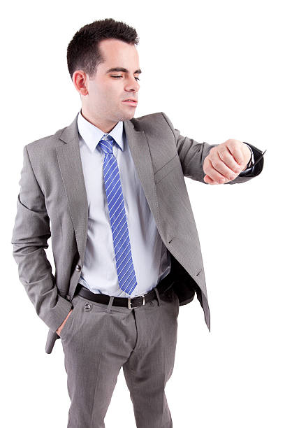 Young business man consulting his watch stock photo