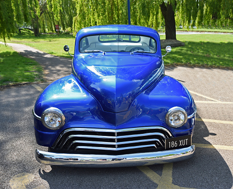 St Neots, Cambridgeshire, England - April 24, 2022: Customised  Blue Plymouth 1947 Coupe isolated in car park.