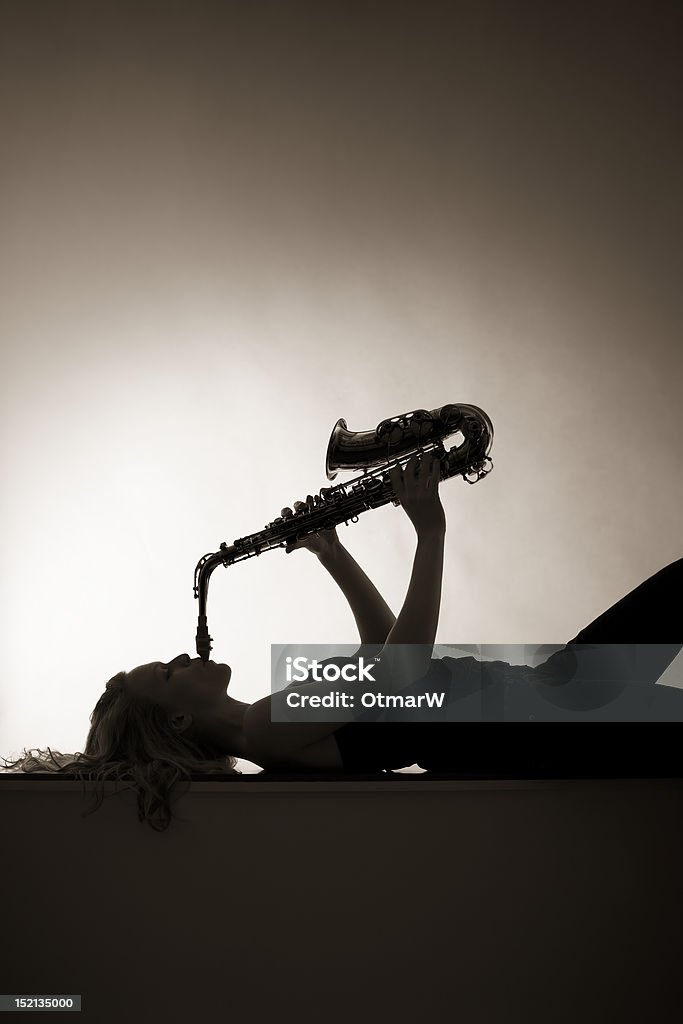 Silueta de mujer tocando saxofón, sepia. - Foto de stock de Acostado libre de derechos