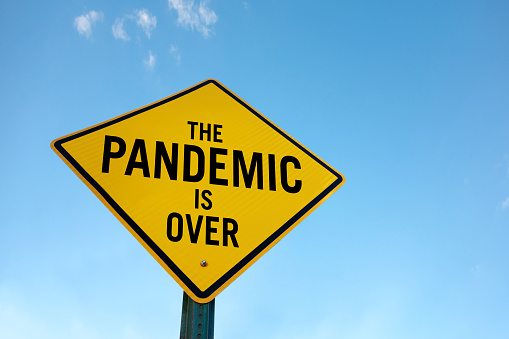 “The pandemic is over” sign in front of a cloudy sky