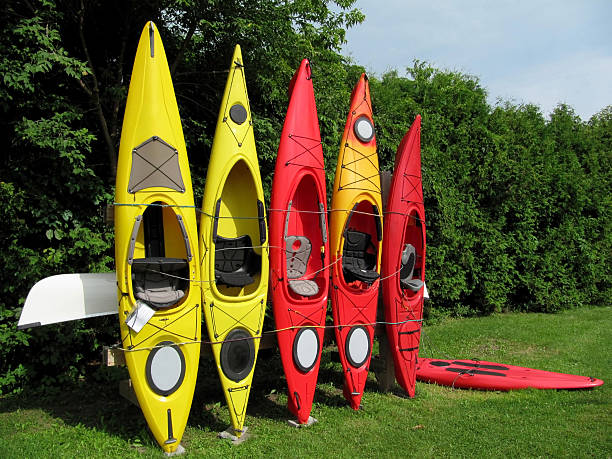 Colorful Kayaks Row of colorful kayaks leaning against wooden rack trishz stock pictures, royalty-free photos & images
