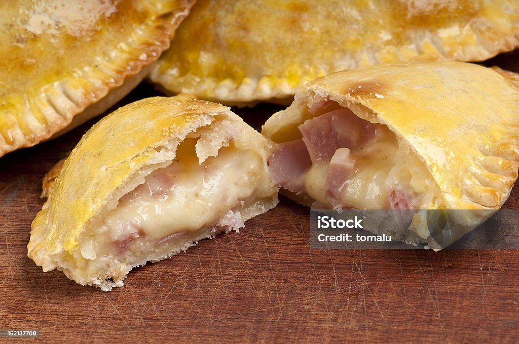 Ham and Cheese Empanada Close Up Ham and Cheese Empanada fill close up.  The Empanada is a pastry turnover filled with a variety of savory ingredients and baked or fried. In some Latin American cultures, the empanada is considered an appetizer and is served before a meal. Empanada Stock Photo