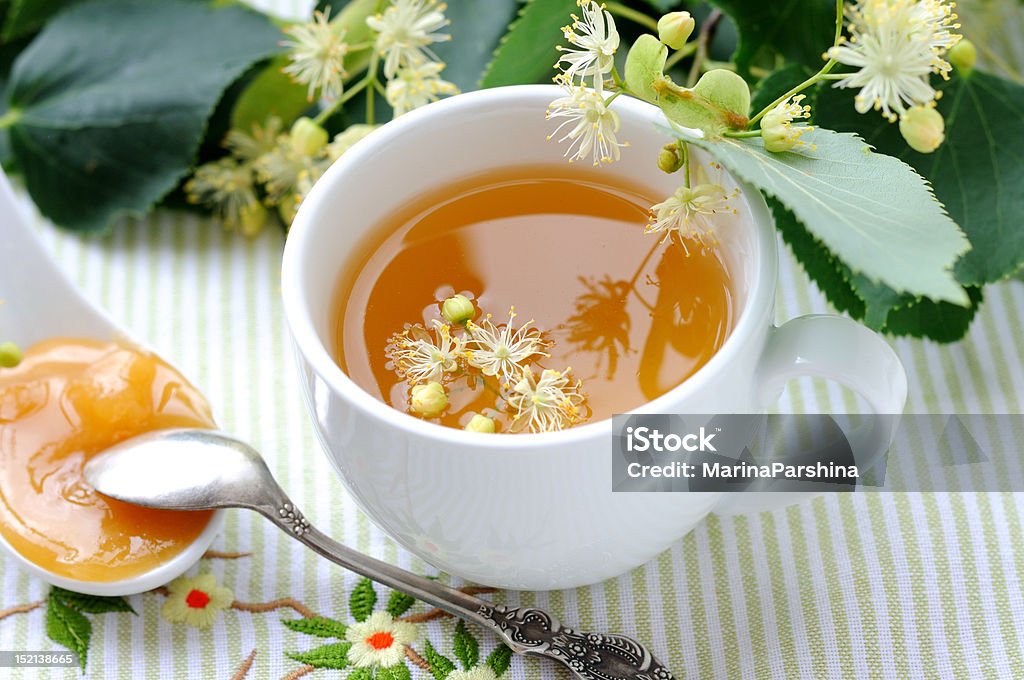 Linden tea White cup  full of linden tea. Branch - Plant Part Stock Photo
