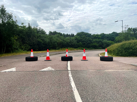 Traffic cones and tyres blocking a road