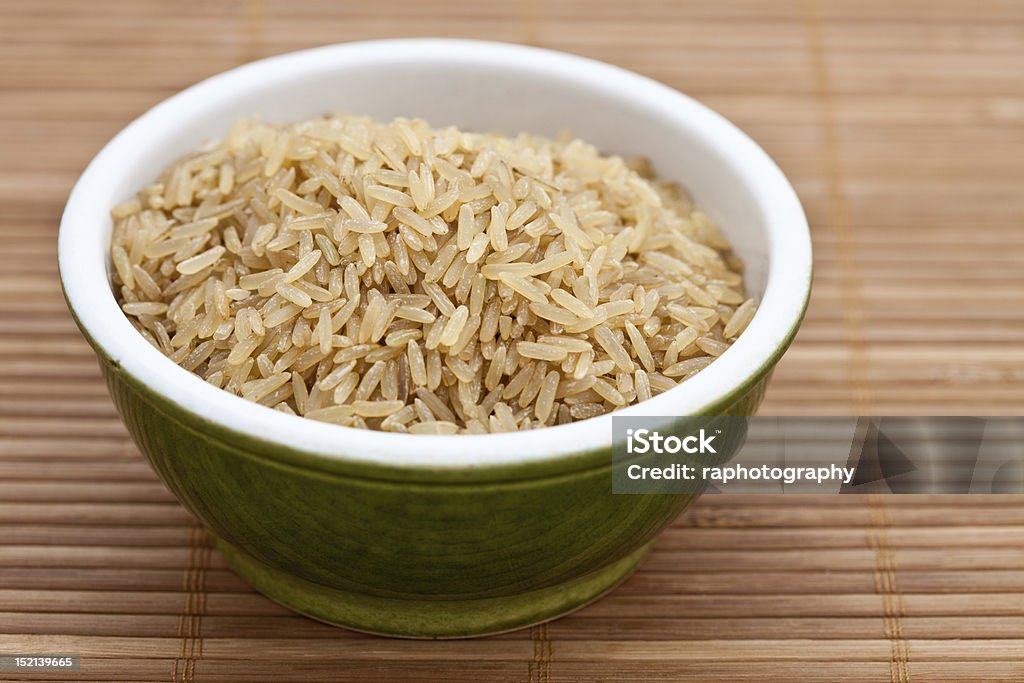 Brown rice in a green bowl Brown rice in a green bowl on a bamboo mat Bowl Stock Photo