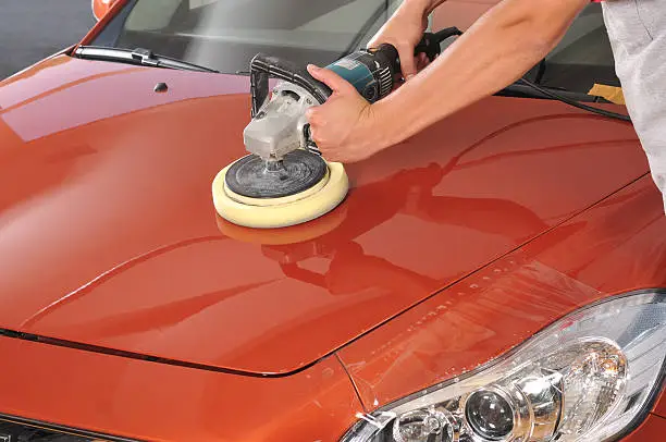 Worker waxing orange car by polishing machine - a series of CAR CARE images.