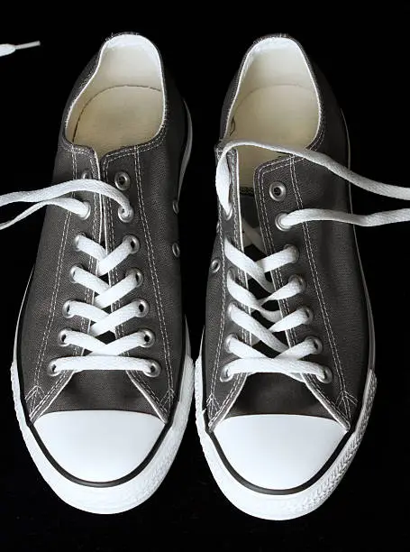 gray sneakers classic youth footwear at black background