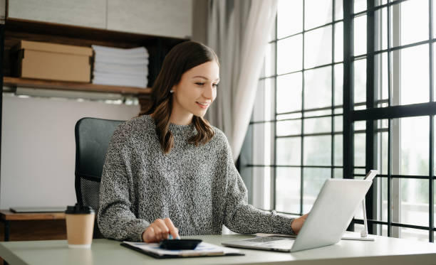 istock Woman freelancer is working her job on computer tablet and laptop Doing accounting analysis report real estate investment data, Financial at office 1521407854