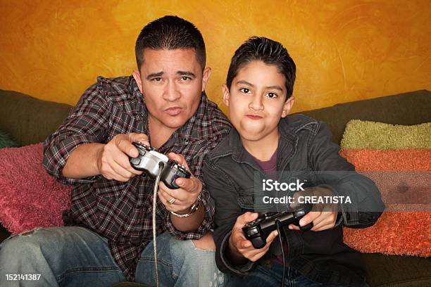 Photo libre de droit de Hispanic Homme Et Petit Garçon Jouant Au Jeu Vidéo banque d'images et plus d'images libres de droit de Latino-américain - Latino-américain, Console de jeu, Famille