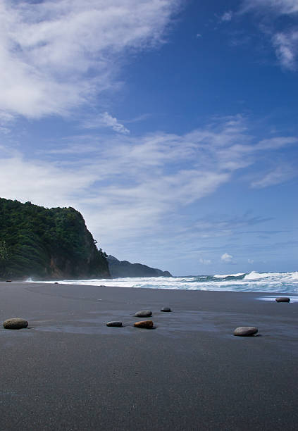 Black sand beach and cliff stock photo